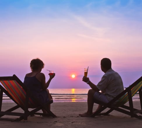 image of a couple sitting on the beach watching the sun set glad that they are covered by the best Retirement Insurance in Franklin, TN
