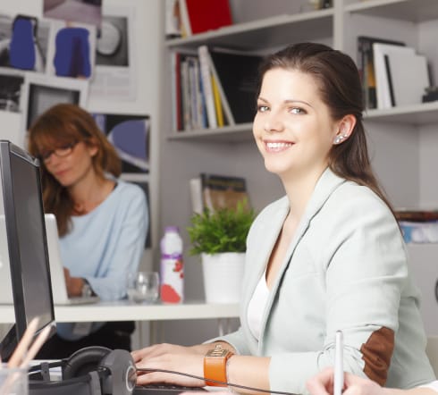 image of a female smiling while typing on a computer beaming with th knowledge that she got the best deal on Errors and Ommissions Insurancein Franklin, TN