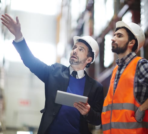 image of two man are inspecting a warehouse, one is holding a notepad, the other just discovered the the best place to buy general liability business insurance in Franklin, TN